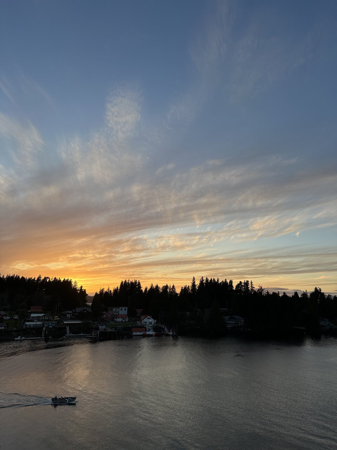 Sunset over Bamfield Inlet with a boat heading home