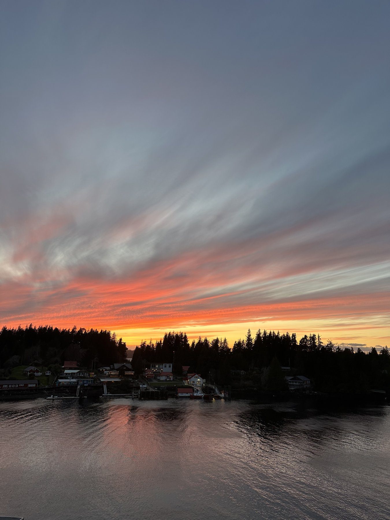 Dramatic orange sunset over Bamfield village and inlet